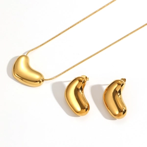 Polished 18k gold bean pendant necklace and matching stud earrings jewelry set display