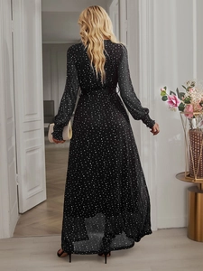 Rear view of long sleeve black polka dot dress with an asymmetrical ruffled hemline
