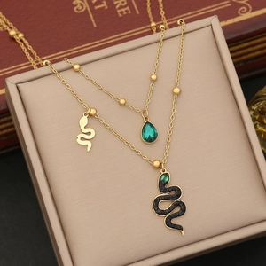 Detail of gold layered chain with green gemstone and black pave snake pendant