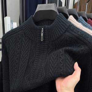 Close-up of black half-zip sweater showing detailed cable knit texture and stand collar