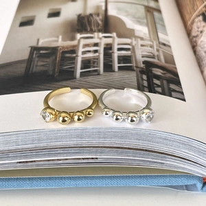 Detailed close-up of beaded 925 silver rings with zircon on a book page background
