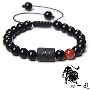 Macro shot of Leo zodiac sign charm on black obsidian beaded braided rope bracelet