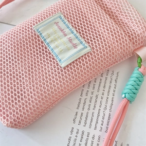 Detail of pink mesh crossbody phone bag with woven strap and studio fabric label