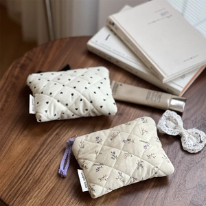Detailed macro of quilted cotton pouches featuring heart prints and floral patterns