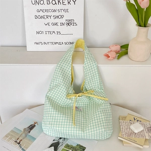 Detail of light green plaid tote bag featuring a contrast yellow drawstring closure