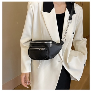 Détail d'un sac bandoulière en similicuir noir avec double fermeture éclair et chaîne