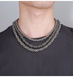 Close-up of layered dark silver Byzantine chain necklaces for men in a trendy hip-hop style