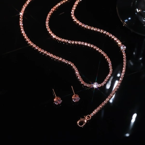 Close-up of rose gold necklace and stud earrings set with sparkling round cubic zirconia