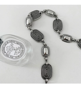 Macro shot of retro silver metal chain links with twisted rope texture and matte finish