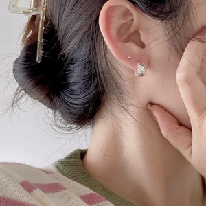 Minimalist 925 sterling silver geometric hoop earrings on a model in natural light
