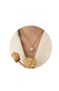 Close-up of 18k gold-plated necklace with a pearl pendant and twisted rope frame