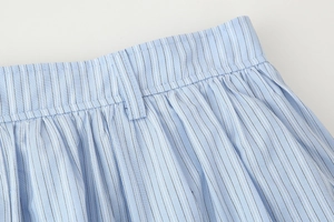 Detailed macro view of the light blue striped skirt waist with pleated fabric texture