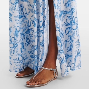 Detail of silver T-strap flat sandals paired with a blue and white floral maxi dress