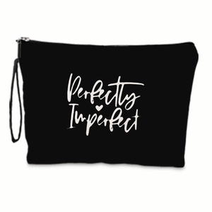 Close-up of black canvas makeup bag with Perfectly Imperfect lettering and wristlet strap