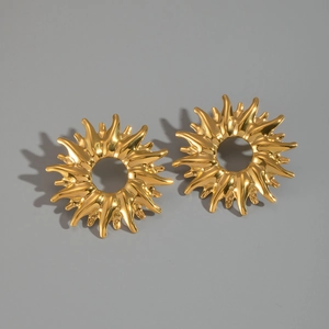 Macro shot of gold sunburst earrings in titanium steel with polished metallic finish