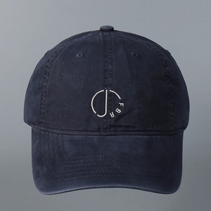 Detail of white embroidered D-letter logo on navy blue washed cotton baseball cap texture