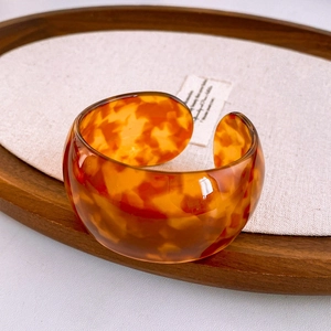 Macro detail of amber tortoiseshell texture on resin wide open cuff bracelet
