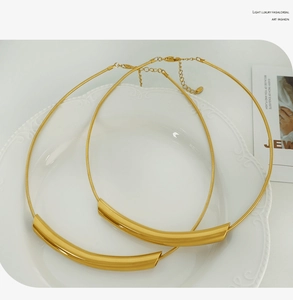 Detailed view of gold plated minimalist curved collar necklace and snake chain set
