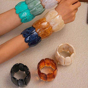 Macro shot of colorful acrylic resin blocks with marble texture on an elastic bracelet