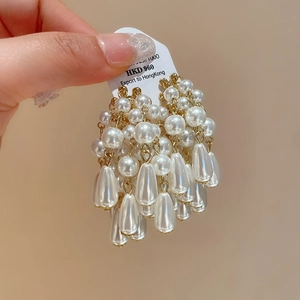 Detail of vintage French style earrings featuring layered white imitation pearl tassels