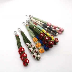 Macro detail of handmade woven daisy flower keychains with metallic lobster clasps