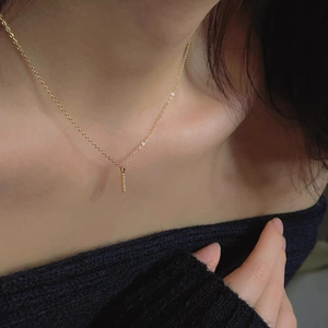 Elegant 14k gold-plated bar necklace with sparkling diamonds worn by a female model