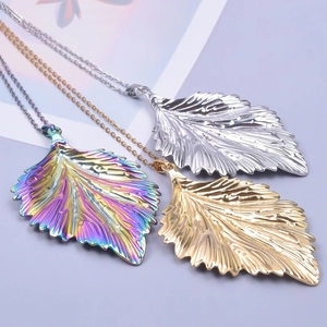 Detailed view of leaf pendants in gold, silver, and rainbow plating with chain