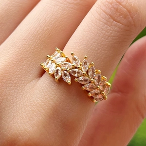 Macro detail of gold-plated wheat-ear ring featuring marquise-cut crystal marquise leaves