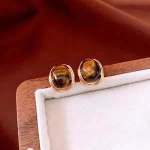 18k gold plated tiger eye square stud earrings shown on white velvet display tray