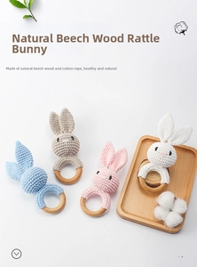Detail of handmade crochet bunny rattle with natural beech wood ring for baby teething