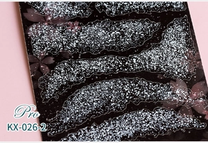 Macro shot of 5D ultra-thin nail stickers with white glitter and pink cherry blossom detail