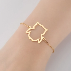Close-up of a minimalist hollow owl pendant bracelet in gold finish on a wrist