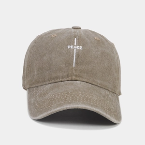 Detail of vintage washed baseball cap featuring white cross and PEACE letter embroidery