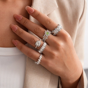 Detail view of silver rings set with crystal zircons and floral patterns on finger