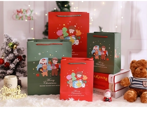 Close-up of Christmas gift bags featuring cartoon Santa and reindeer with woven handles