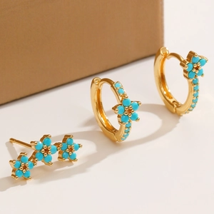 Detailed macro view of gold-plated earrings set with blue turquoise stones and zircon
