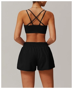 Détail de la brassière de sport noire à dos croisé et du short de yoga assorti