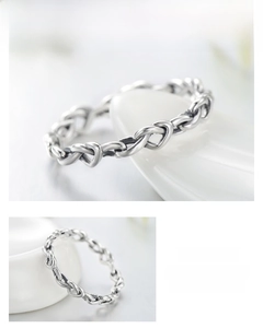 Detailed view of silver heart-shaped intertwined chain ring with vintage texture