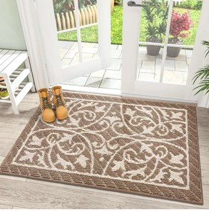 Detalle de textura de felpudo marrón con motivos florales beige sobre suelo de madera