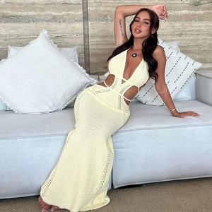 Detail of light yellow knit halter dress featuring intricate hollow-out waist design