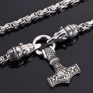 Detailed close-up of Viking Mjolnir pendant with wolf head accents on stainless steel chain