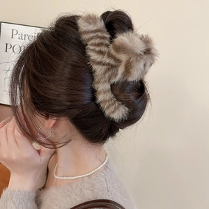 Detailed view of plush shark hair clip with brown animal stripes for winter styling