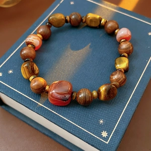 Gros plan de perles œil de tigre et agate sur un livre ancien aux détails fins