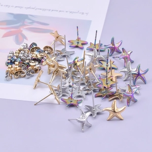 Macro detail of starfish earrings in gold, silver, and rainbow steel with textured surface