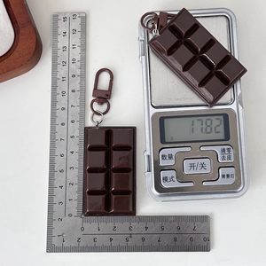 Realistic chocolate bar keychain in dark brown with 17.82g weight on a scale