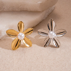 Elegant gold and silver metallic flower rings with pearl center on minimalist stone background