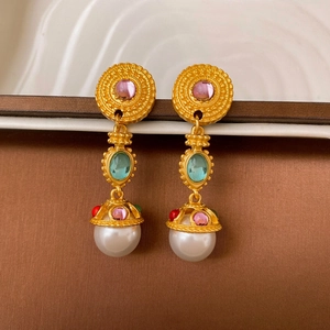 Detail of vintage gold earrings with pink and blue stones and large drop pearls
