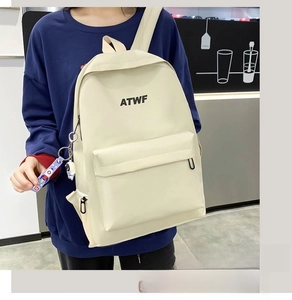 Detail of off-white backpack with ATWF logo and aerospace pendant in casual style
