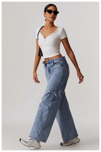 Detail of white V-neck short sleeve yoga T-shirt with buttons and wide leg jeans