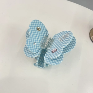 Detail of light blue checkerboard butterfly hair claw with MISS rhinestone lettering